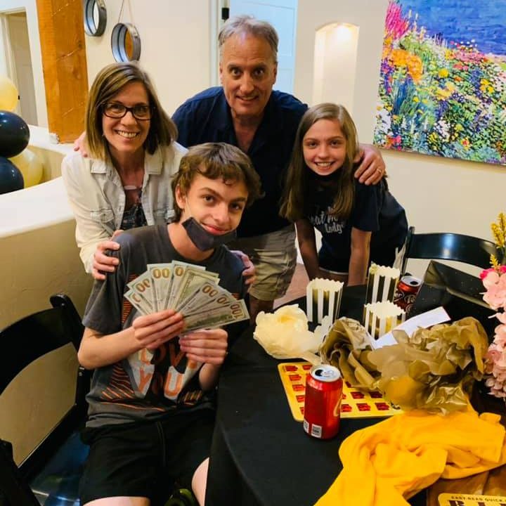 Family of 4 holding cash winnings from Park Senior Villas' Bing Extravaganza Event