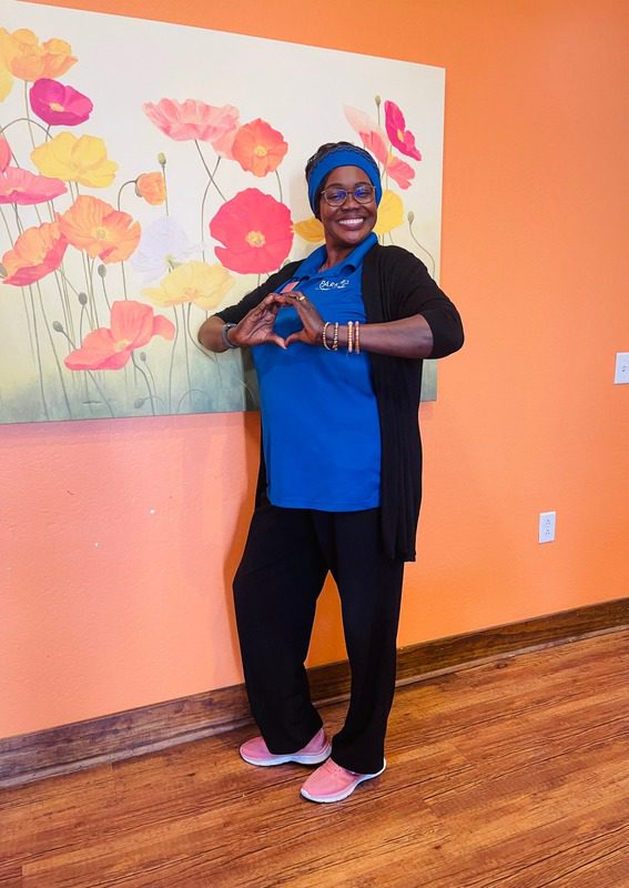 Park Senior Villas resident smiling happily inside while making a heart with her hands