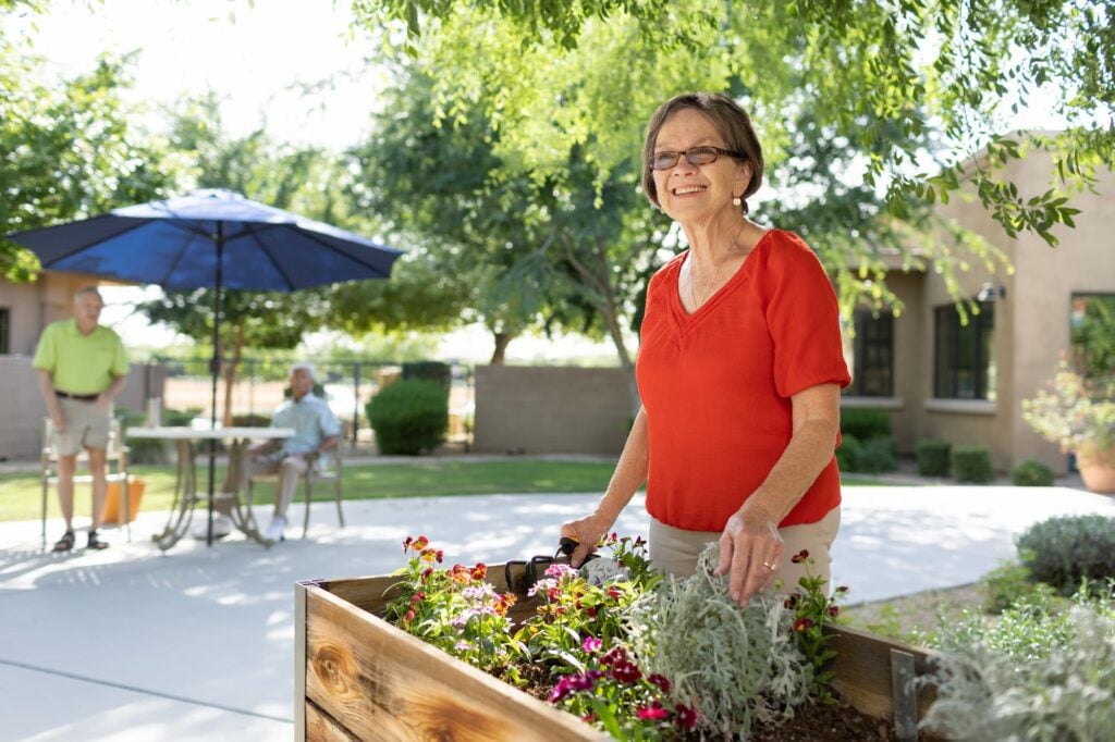 senior woman smiling as she looks out at her outdoor garden